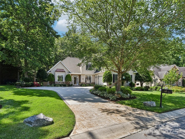 145 Fernbrook Way, Hendersonville, NC 28791 - view of front facade with decorative driveway, stucco siding, a front yard, an attached garage, and stone siding