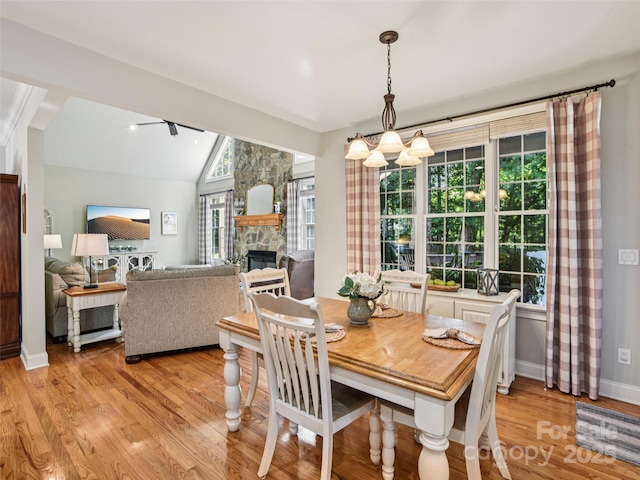 145 Fernbrook Way, Hendersonville, NC 28791 - dining space with light wood-style floors, a fireplace, vaulted ceiling, and a chandelier