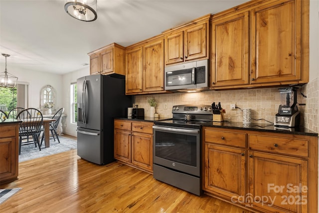 121 Maplewood Ct, Hudson, NC 28638 - kitchen with appliances with stainless steel finishes, brown cabinetry, light wood-style floors, and tasteful backsplash