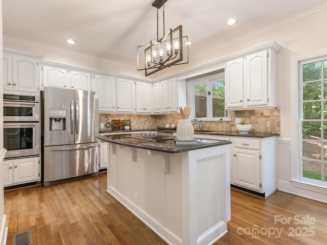 10333 Scott Gate Ct, Charlotte, NC 28277 - kitchen featuring stainless steel appliances, white cabinetry, wood finished floors, crown molding, and a kitchen island