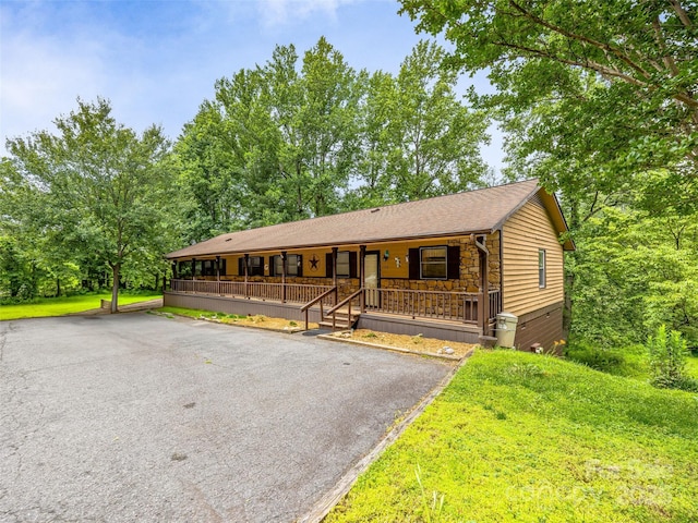 128 View De Lake Dr, Etowah, NC 28729 - view of front of property featuring covered porch, stone siding, a shingled roof, and driveway