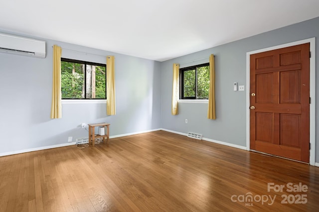 55 Lookout Dr, Asheville, NC 28804 - spare room with a wall mounted air conditioner, plenty of natural light, and wood finished floors