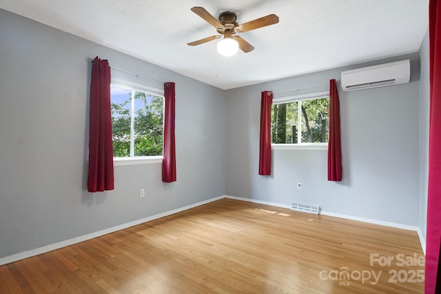 55 Lookout Dr, Asheville, NC 28804 - spare room featuring an AC wall unit, healthy amount of natural light, wood finished floors, and a ceiling fan