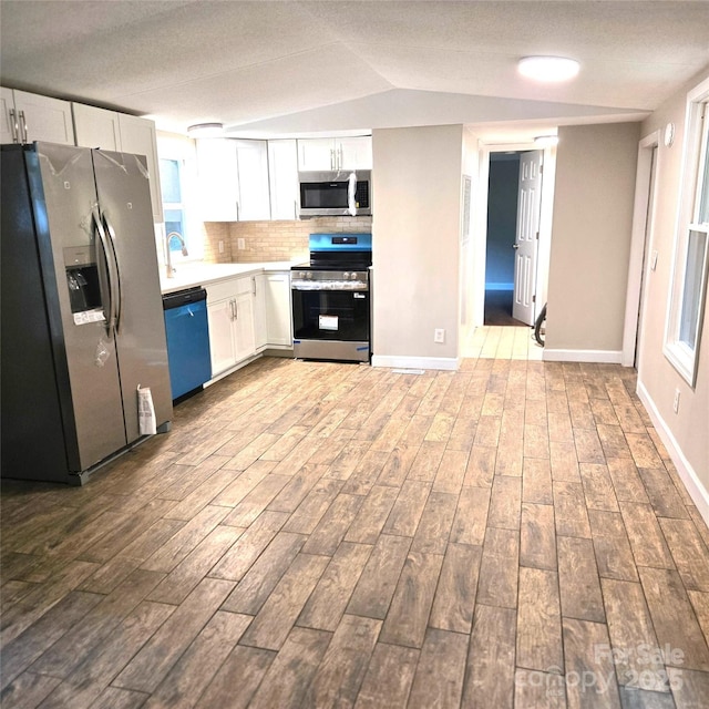 105 Damron Ln Unit 20, Harmony, NC 28634 - kitchen featuring stainless steel appliances, dark wood-style floors, white cabinetry, tasteful backsplash, and lofted ceiling