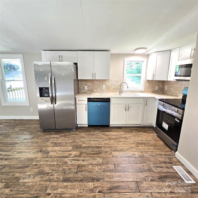 105 Damron Ln Unit 20, Harmony, NC 28634 - kitchen with stainless steel appliances, dark wood-style floors, white cabinets, and light countertops
