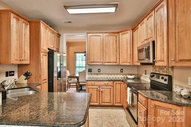 111 Painted Bunting Dr, Troutman, NC 28166 - kitchen with appliances with stainless steel finishes, light tile patterned flooring, backsplash, and dark stone counters