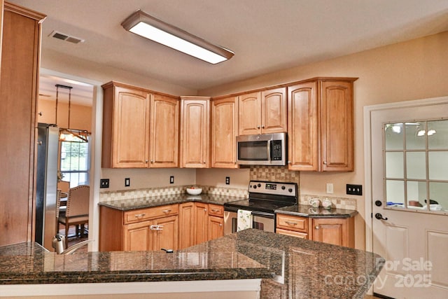 111 Painted Bunting Dr, Troutman, NC 28166 - kitchen with stainless steel appliances, a peninsula, dark stone counters, decorative light fixtures, and backsplash