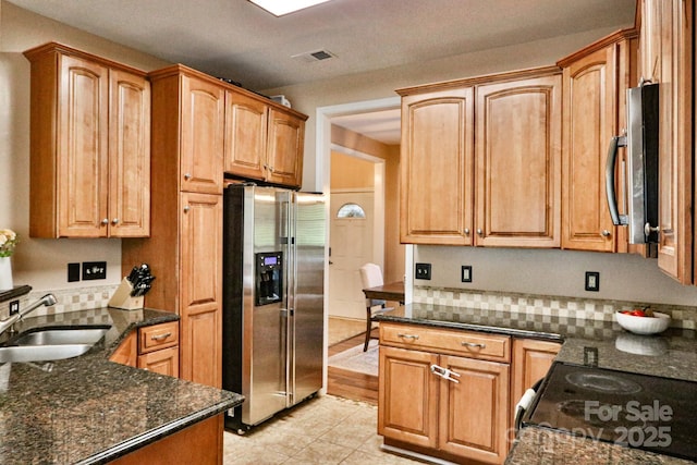 111 Painted Bunting Dr, Troutman, NC 28166 - kitchen with appliances with stainless steel finishes, dark stone countertops, decorative backsplash, and light tile patterned flooring