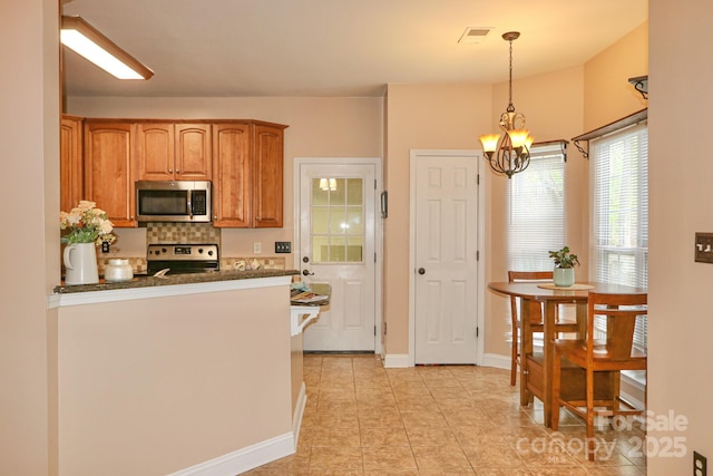 111 Painted Bunting Dr, Troutman, NC 28166 - kitchen with stainless steel appliances, a chandelier, brown cabinets, backsplash, and light tile patterned floors