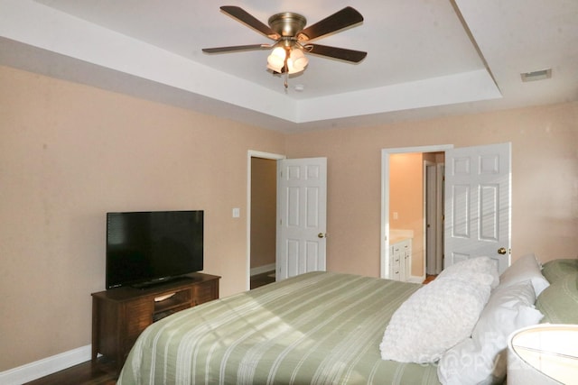 111 Painted Bunting Dr, Troutman, NC 28166 - bedroom with a raised ceiling, ensuite bath, a ceiling fan, and dark wood finished floors