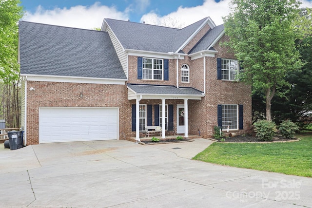 111 Painted Bunting Dr, Troutman, NC 28166 - view of front of house featuring a porch, concrete driveway, brick siding, roof with shingles, and a front yard