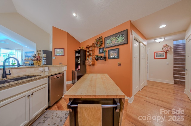 38 Westfield Way, Candler, NC 28715 - kitchen featuring dishwasher, light wood finished floors, vaulted ceiling, light stone countertops, and white cabinetry