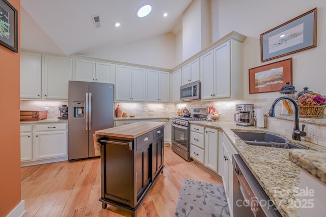 38 Westfield Way, Candler, NC 28715 - kitchen with stainless steel appliances, white cabinetry, butcher block countertops, tasteful backsplash, and light wood finished floors