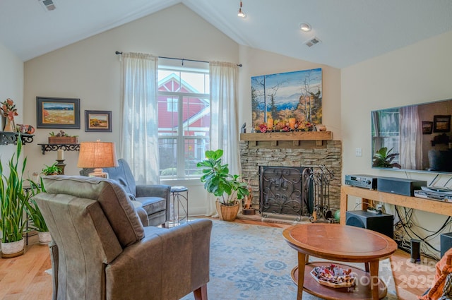 38 Westfield Way, Candler, NC 28715 - living area featuring wood finished floors, vaulted ceiling, and a stone fireplace