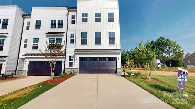 2143 Barrowcliffe Dr NW, Concord, NC 28027 - view of front of house with board and batten siding, a standing seam roof, a garage, and stone siding
