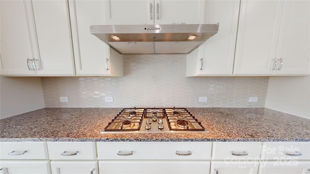 2143 Barrowcliffe Dr NW, Concord, NC 28027 - kitchen with ventilation hood, stainless steel gas cooktop, white cabinetry, and decorative backsplash