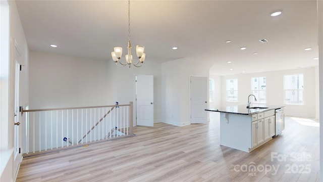 2143 Barrowcliffe Dr NW, Concord, NC 28027 - kitchen with light wood-style flooring, white cabinets, a center island with sink, a chandelier, and recessed lighting