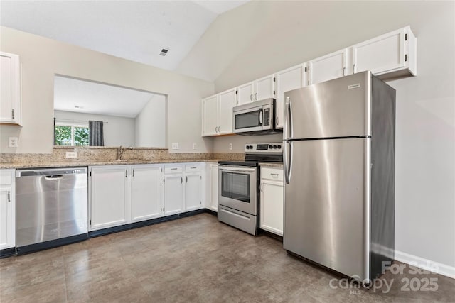 8724 Tweedsmuir Glen Ln, Charlotte, NC 28215 - kitchen featuring stainless steel appliances, white cabinetry, vaulted ceiling, and light stone counters