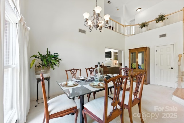 7014 Walton Heath Ln, Charlotte, NC 28277 - dining room with light carpet, a chandelier, and a towering ceiling
