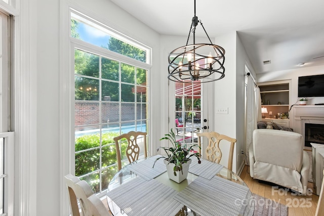 7014 Walton Heath Ln, Charlotte, NC 28277 - dining area featuring a chandelier, wood finished floors, and a fireplace