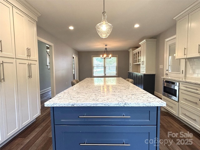 1335 33rd Avenue Dr NE, Hickory, NC 28601 - kitchen with dark wood-style floors, recessed lighting, hanging light fixtures, a center island, and light stone counters