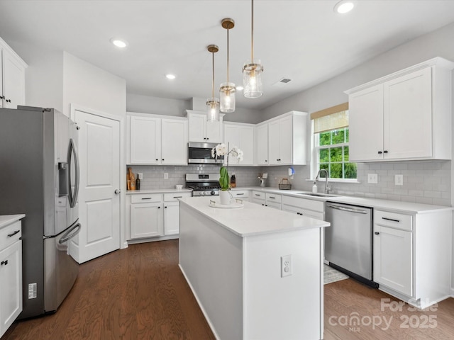 1008 Whipcord Dr, Waxhaw, NC 28173 - kitchen featuring stainless steel appliances, dark wood-type flooring, light countertops, white cabinets, and tasteful backsplash