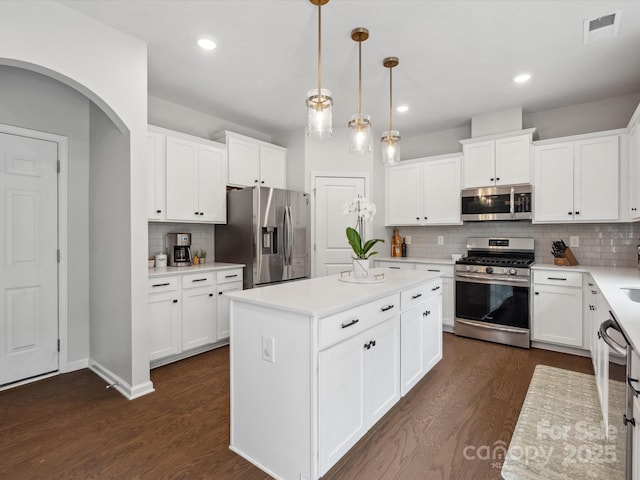 1008 Whipcord Dr, Waxhaw, NC 28173 - kitchen with appliances with stainless steel finishes, backsplash, a center island, dark wood-style floors, and light countertops