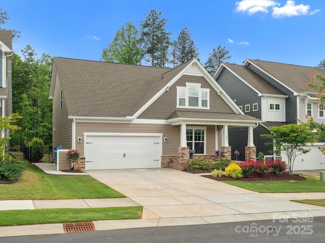 1008 Whipcord Dr, Waxhaw, NC 28173 - craftsman-style home featuring covered porch, concrete driveway, a front lawn, stone siding, and roof with shingles