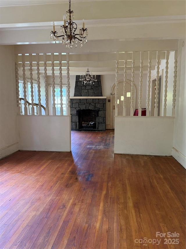 3985 1st Ave SW, Hickory, NC 28602 - unfurnished living room featuring a chandelier, hardwood / wood-style floors, a stone fireplace, and crown molding