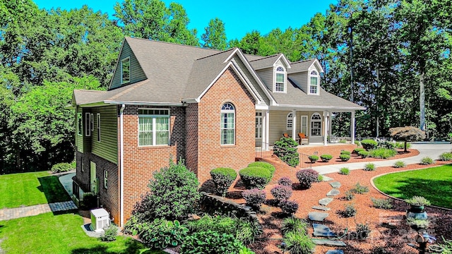 133 Sassafras Hill Dr, Rutherfordton, NC 28139 - cape cod-style house with a front lawn, brick siding, covered porch, and roof with shingles