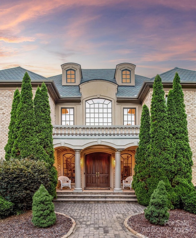 9110 Woodhall Lake Dr, Waxhaw, NC 28173 - french country home with stucco siding, a porch, and brick siding