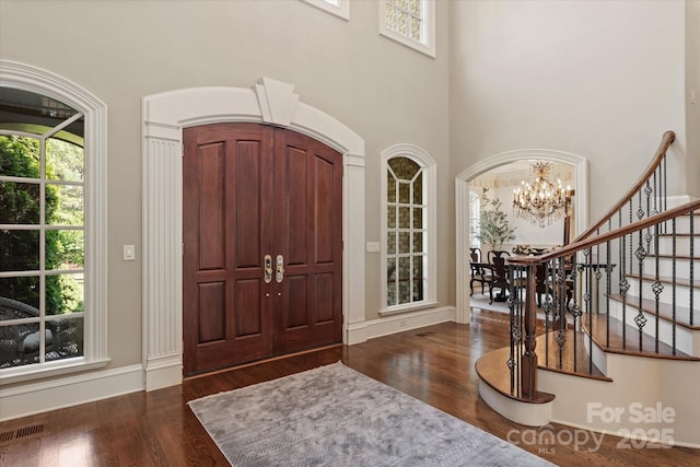 9110 Woodhall Lake Dr, Waxhaw, NC 28173 - entryway featuring healthy amount of natural light, dark wood-style floors, a chandelier, and a towering ceiling