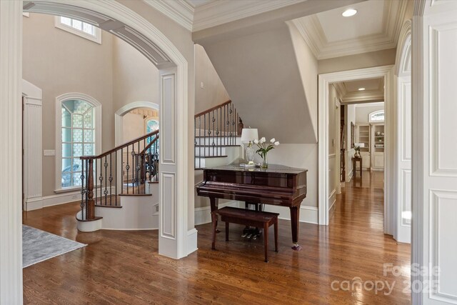 9110 Woodhall Lake Dr, Waxhaw, NC 28173 - foyer featuring wood finished floors, healthy amount of natural light, stairs, ornamental molding, and arched walkways