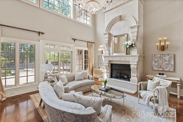 9110 Woodhall Lake Dr, Waxhaw, NC 28173 - living room featuring a chandelier, a high ceiling, dark wood-style flooring, and a fireplace