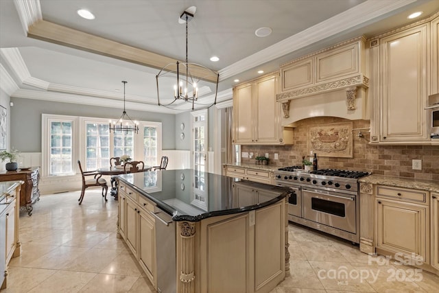 9110 Woodhall Lake Dr, Waxhaw, NC 28173 - kitchen featuring range with two ovens, cream cabinetry, a chandelier, tasteful backsplash, and ornamental molding