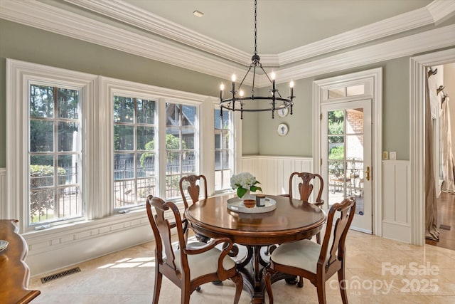 9110 Woodhall Lake Dr, Waxhaw, NC 28173 - dining area featuring healthy amount of natural light, wainscoting, a chandelier, a decorative wall, and ornamental molding
