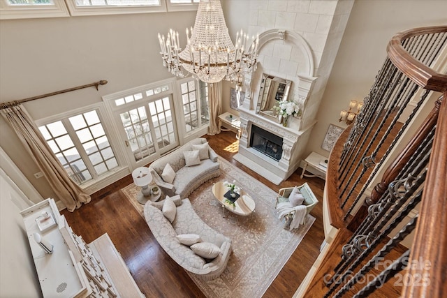9110 Woodhall Lake Dr, Waxhaw, NC 28173 - living room with wood finished floors, a chandelier, healthy amount of natural light, a tile fireplace, and a high ceiling