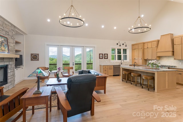 48 Falling Leaves Ln, Hendersonville, NC 28792 - living area with a chandelier, high vaulted ceiling, light wood finished floors, a stone fireplace, and recessed lighting