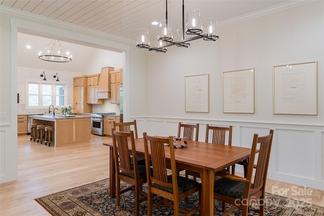 48 Falling Leaves Ln, Hendersonville, NC 28792 - dining area with a chandelier, crown molding, light wood finished floors, a decorative wall, and a wainscoted wall