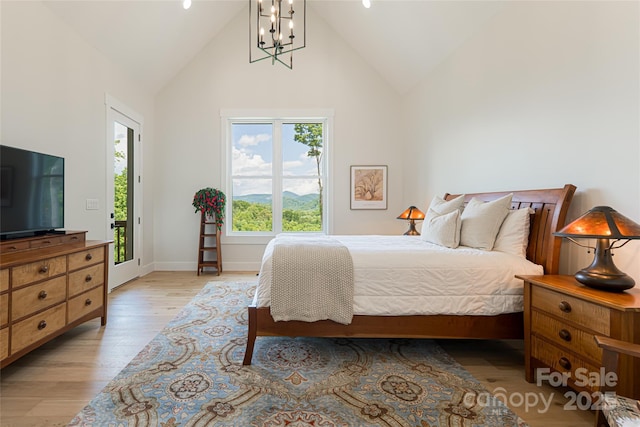 48 Falling Leaves Ln, Hendersonville, NC 28792 - bedroom with high vaulted ceiling, light wood-style flooring, and a chandelier