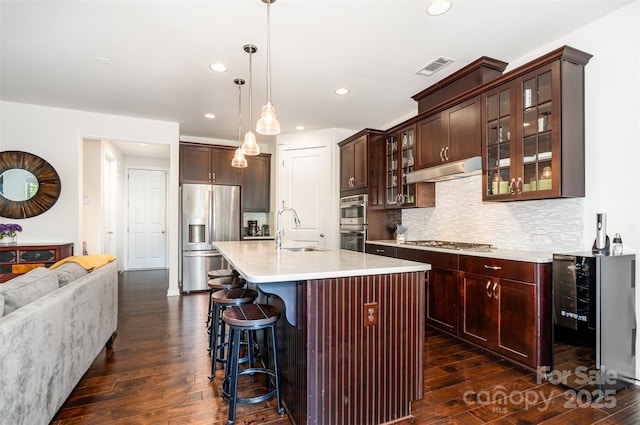11225 Black Brant Ln, Charlotte, NC 28278 - kitchen featuring appliances with stainless steel finishes, wine cooler, dark wood finished floors, under cabinet range hood, and recessed lighting