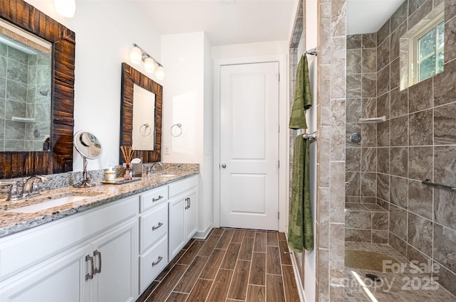 11225 Black Brant Ln, Charlotte, NC 28278 - bathroom with double vanity, a tile shower, and wood finish floors
