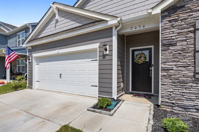 2036 Vanderlyn St, Monroe, NC 28112 - view of exterior entry with stone siding, concrete driveway, and a garage
