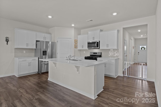 2036 Vanderlyn St, Monroe, NC 28112 - kitchen with stainless steel appliances, backsplash, white cabinetry, a center island with sink, and recessed lighting