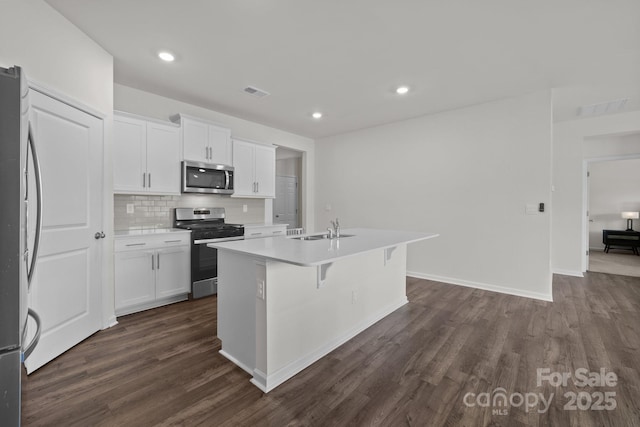 2036 Vanderlyn St, Monroe, NC 28112 - kitchen featuring stainless steel appliances, dark wood-style floors, white cabinetry, tasteful backsplash, and recessed lighting