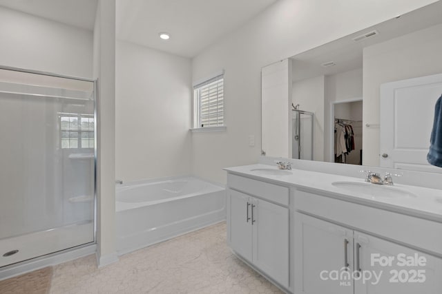 2036 Vanderlyn St, Monroe, NC 28112 - bathroom with double vanity, a garden tub, a shower stall, and a walk in closet