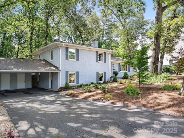 4618 Emory Ln, Charlotte, NC 28211 - tri-level home featuring a chimney, asphalt driveway, and brick siding