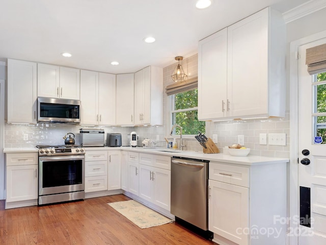 4618 Emory Ln, Charlotte, NC 28211 - kitchen with appliances with stainless steel finishes, plenty of natural light, white cabinetry, recessed lighting, and ornamental molding