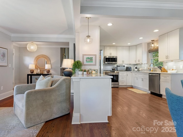 4618 Emory Ln, Charlotte, NC 28211 - kitchen with appliances with stainless steel finishes, white cabinets, wood finished floors, tasteful backsplash, and crown molding