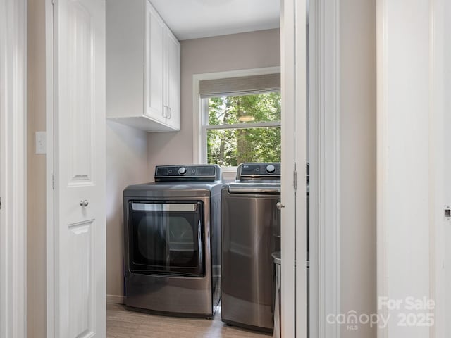 4618 Emory Ln, Charlotte, NC 28211 - washroom featuring separate washer and dryer, cabinet space, and light wood finished floors